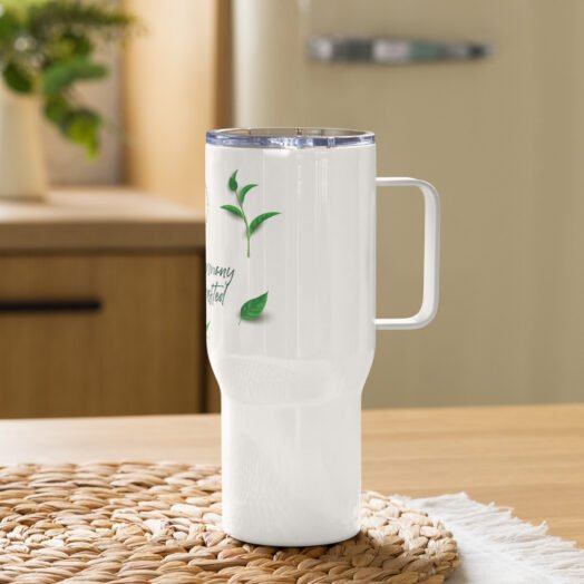 White insulated tumbler with plant design on table.