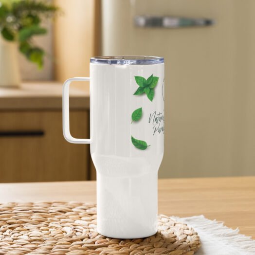 Insulated travel mug with green leaves design on table.